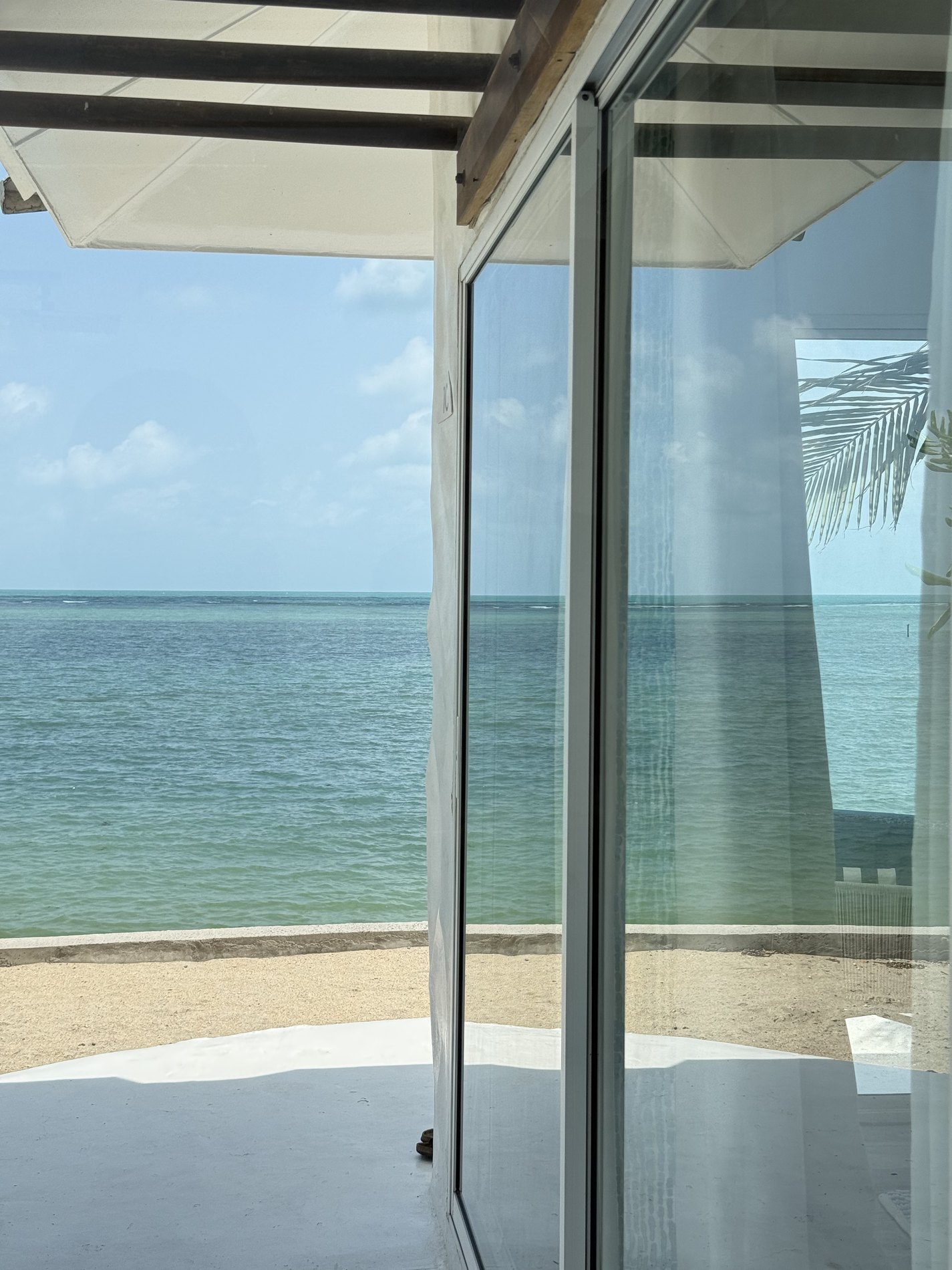 Turquoise ocean view through open villa doors